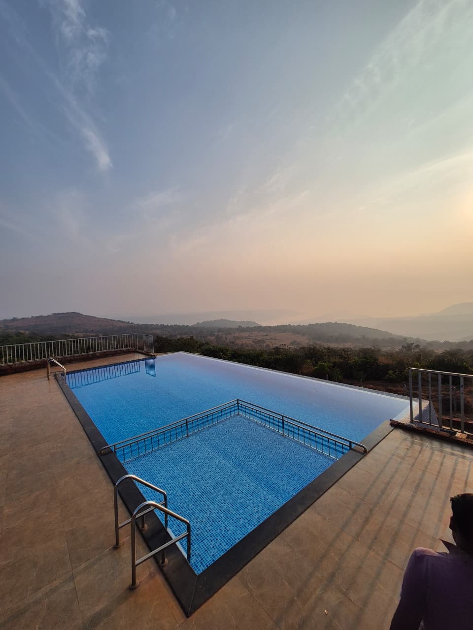 Pool contractor — Hilltop infinity-edge pool at sunset overlooking the valley