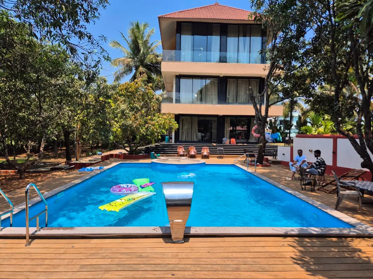 Pool contractor — Goa villa pool with wooden deck and water feature