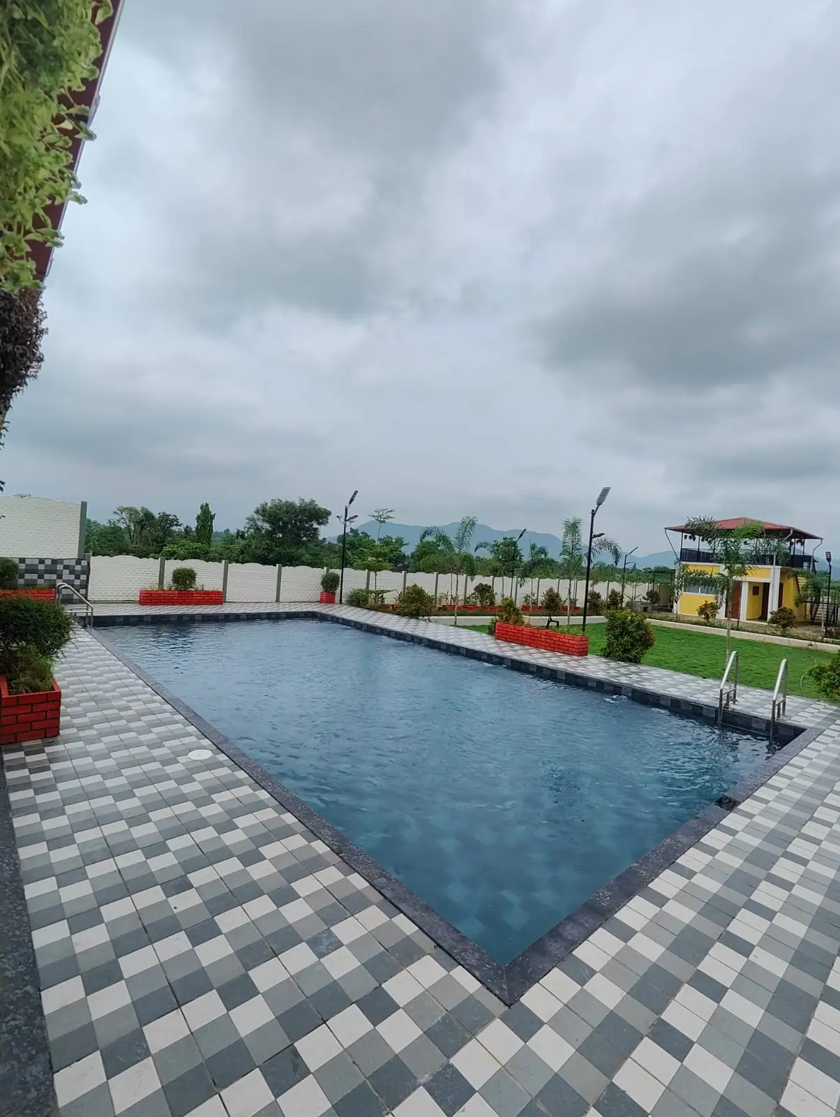 Pool contractor — Farmhouse pool with checkered deck and hill views