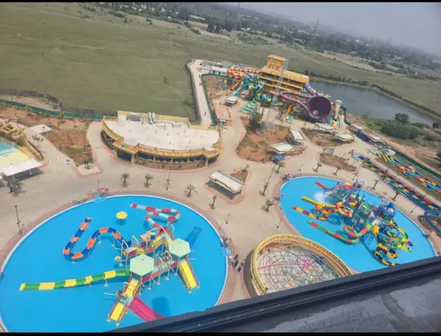 Pool contractor — Aerial view of a multi-zone water park developed by Dreamz Pools — wave pool, slide tower and family activity pools