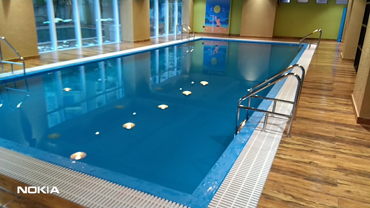 Pool contractor — Indoor lap pool with underwater lighting and wooden decking