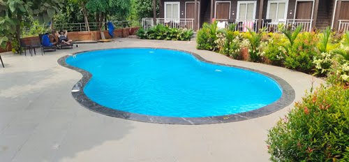 Pool contractor — Freeform kidney-shaped resort swimming pool with landscaped garden